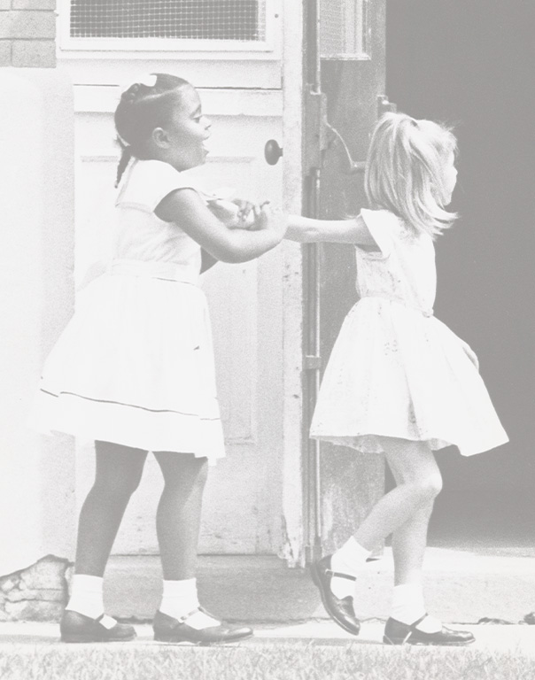 Black girl and white girl playing in a desegregated school