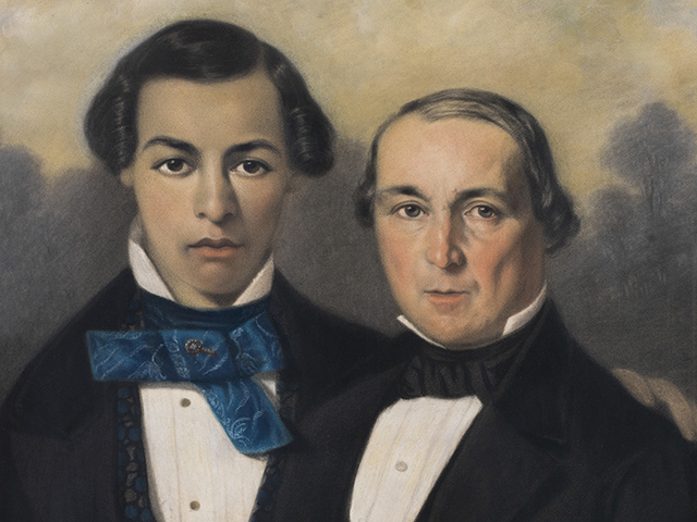 portrait of two elegantly dressed men; younger man with darker complexion on left and older man on right; pair are positioned close to each other suggesting close relationship