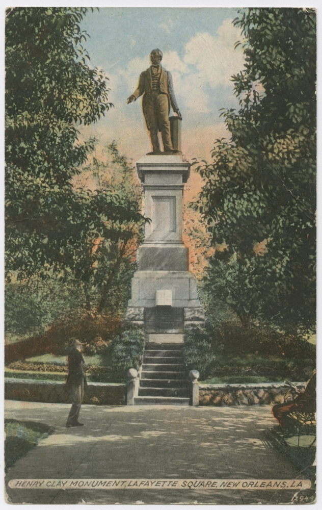 Circa 1910 postcard reproduced from a photograph showing the Henry Clay Monument, located in Lafayette Square. The monument consists of a statue of Clay standing atop of a square grey pedestal slightly taller than the statue. The monument is placed on raised, circular bed of grass and flowers, and the scene is framed by leafy green trees on either side. On the left, a man stands near the flower beds, looking up at the statue, and on the right a man sits on a park bench, reading.