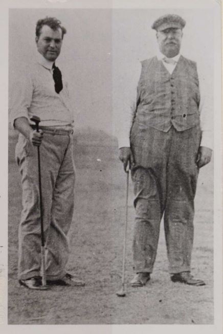Two men pose on a golf course.