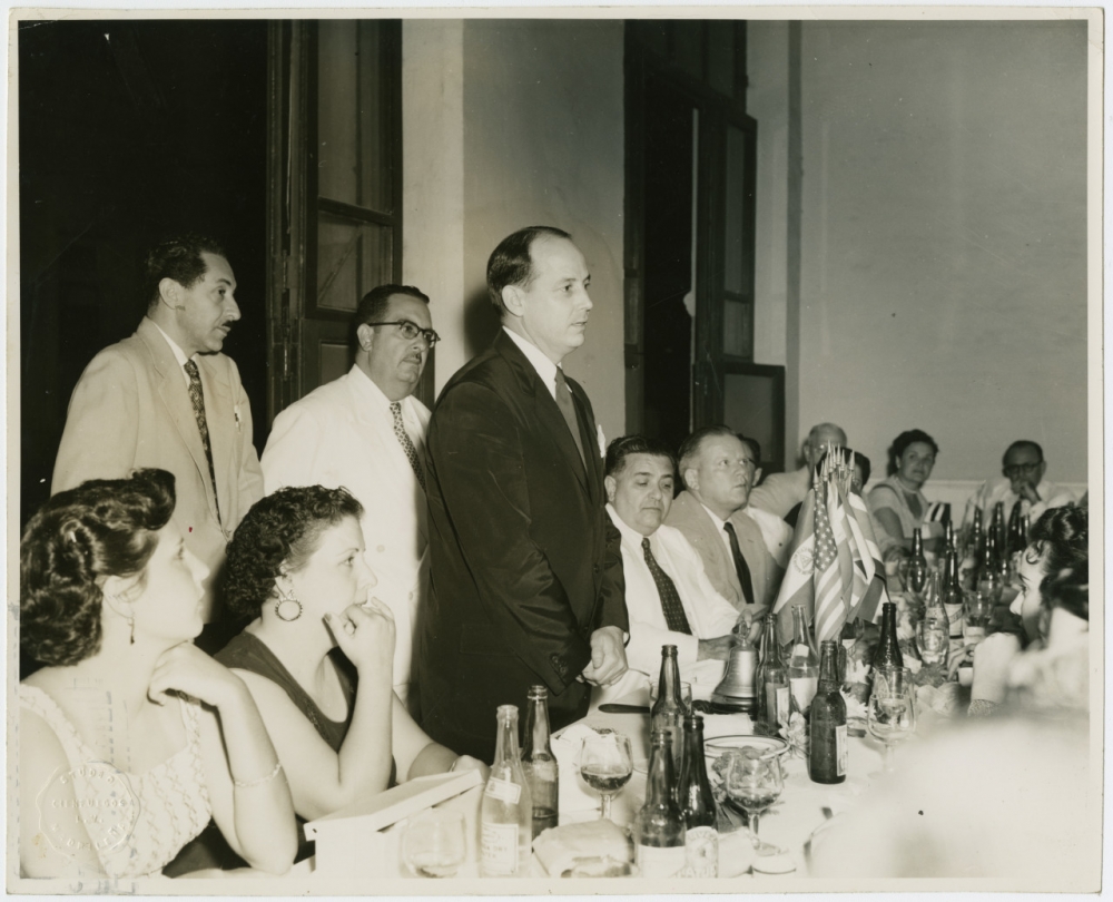  View of New Orleans Mayor "Chep" Morrison at a banquet in Cienfuegos, Cuba with Cuban citizens seated around table.