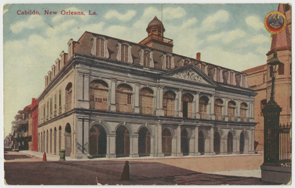 Circa 1910  view of the Cabildo on Jackson Square in the Vieux Carré, showing buildings on St. Peter Street, partial view of St. Louis Cathedral, and lamppost of fence around Jackson Square. 