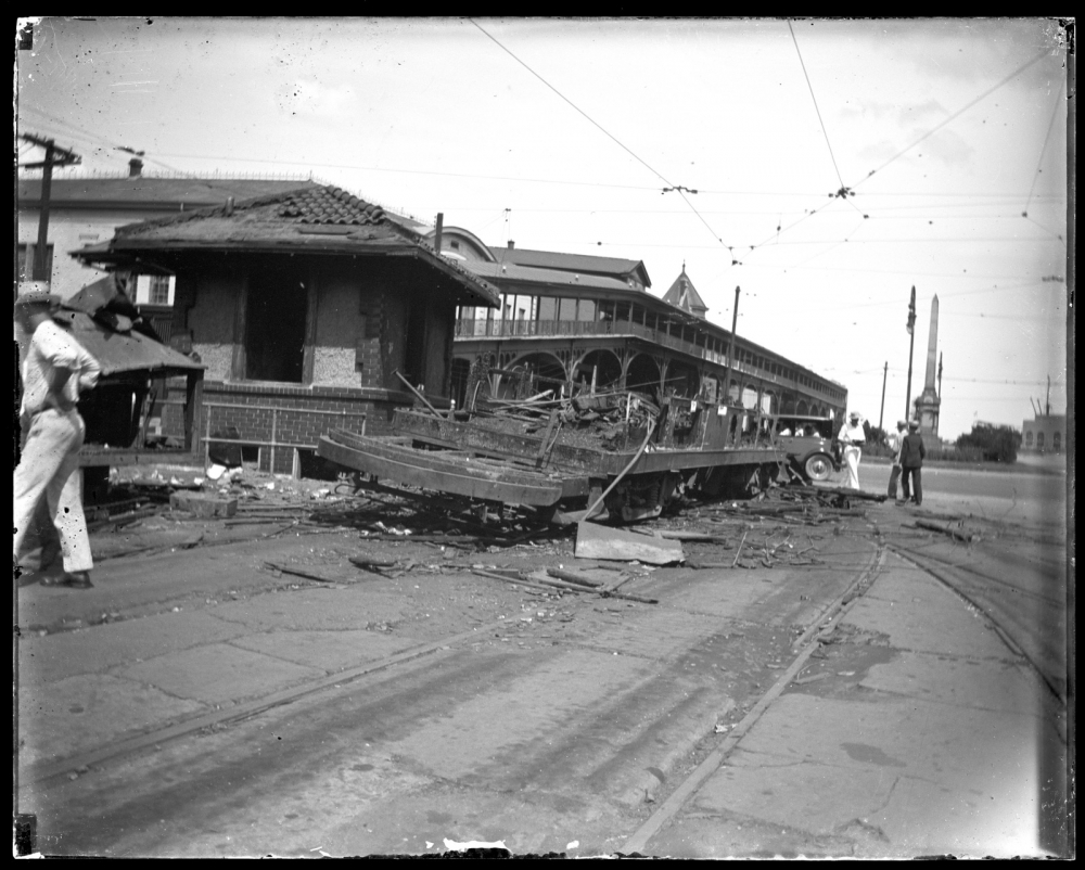 	View made during the 1929 transit strike that shows a burnt streetcar and damaged toolshed on the neutral ground of Canal Street. The Louisville & Nashville Railroad Station is partially visible in the background and the Liberty Place Monument, also in the 100 block of Canal Street is also seen.