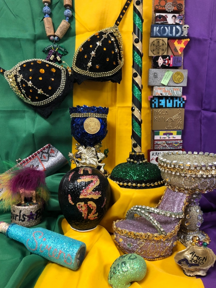 Tableau of custom Carnival throws, including Muses shoe, Zulu coconut, and Tucks toilet plunger