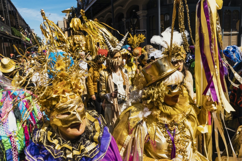 2019 full color image by Ryan Hodgson-Rigsbee showing members of the Krewe of Red Beans marching on Mardi Gras day. The image shows a dense crowd with most parade-goers wearing gold (it was the Krewe's 50th anniversary) and carrying poles decorated with colorful ribbons and streamers. 
